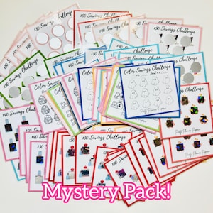 May include: A collection of colorful savings challenge cards with various designs, including cupcakes, ghosts, and perfume bottles. The cards have different amounts, such as $30, $40, and $50, and are labeled "Color Savings Challenge" and "Mystery Pack!"