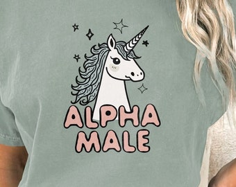 May include: A light green t-shirt with a white unicorn graphic and the text "ALPHA MALE" in pink letters.