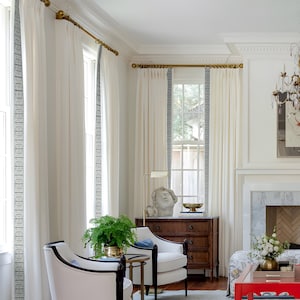 A pair of cotton linen curtains with white trim that can be customized to lengthen.