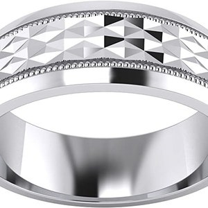 Puede incluir: Una banda de boda de plata con un patr&oacute;n de diamante y un borde de cuentas.