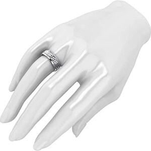 Puede incluir: Un anillo de plata con un dise&ntilde;o texturizado. El anillo se lleva en el dedo de una modelo.