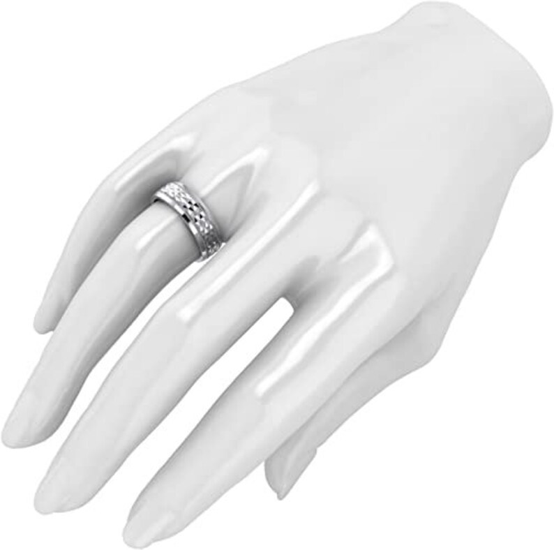 Puede incluir: Un anillo de plata con un dise&ntilde;o texturizado. El anillo se lleva en el dedo de una modelo.