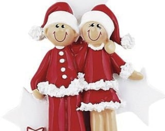 May include: A Christmas bauble depicting a couple in red pyjamas with white trim, standing together against a white star background.