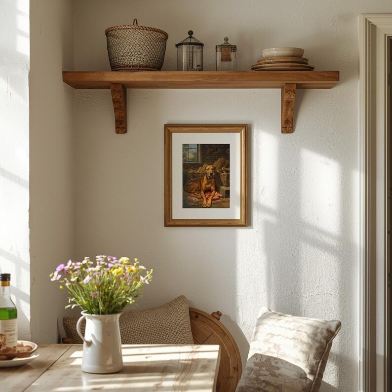 K&ouml;nnte beinhalten: Rustikales Interieur mit einem Holzregal mit einem Weidenkorb, Gl&auml;sern und Tellern. Darunter h&auml;ngt ein gerahmtes Gem&auml;lde eines Hundes. Eine wei&szlig;e Vase mit Blumen und ein Esstisch vervollst&auml;ndigen die gem&uuml;tliche Szene.