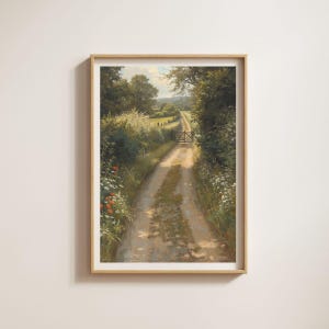 Op de afbeelding: Een ingelijste kunstdruk met een landelijk landschap met een onverharde weg die door velden en bomen slingert. De afbeelding toont een pad omzoomd door wilde bloemen en groen, dat leidt naar een houten poort. Het kleurenschema wordt gedomineerd door groen, bruin en vleugjes rood.