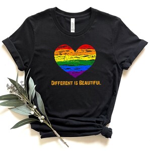 May include: Black t-shirt with a rainbow heart and the text "Different is Beautiful" in orange.
