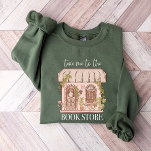 May include: A green sweatshirt with a graphic of a bookstore with the text "Take me to the Book Store".