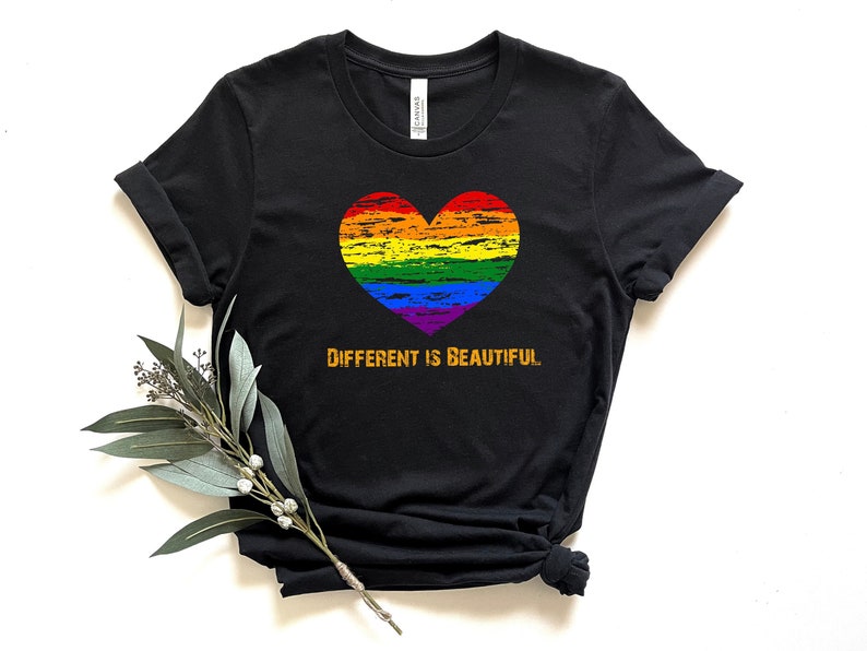 May include: Black t-shirt with a rainbow heart and the text "Different is Beautiful" in orange.