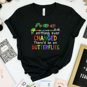 May include: Black t-shirt with a colorful graphic of a caterpillar and butterflies. The text on the shirt reads "If nothing ever CHANGED There'd be no BUTTERFLIES".