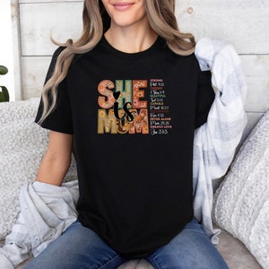 May include: Black t-shirt with a colourful graphic that says "She is Mom" with bible verses.