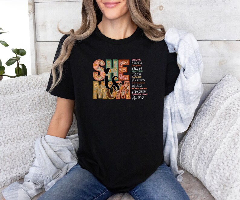 May include: Black t-shirt with a colourful graphic that says "She is Mom" with bible verses.