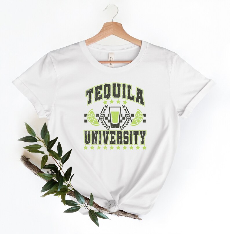 May include: White t-shirt with a green and black graphic that says "Tequila University". The graphic features a shot glass with lime wedges and a laurel wreath.