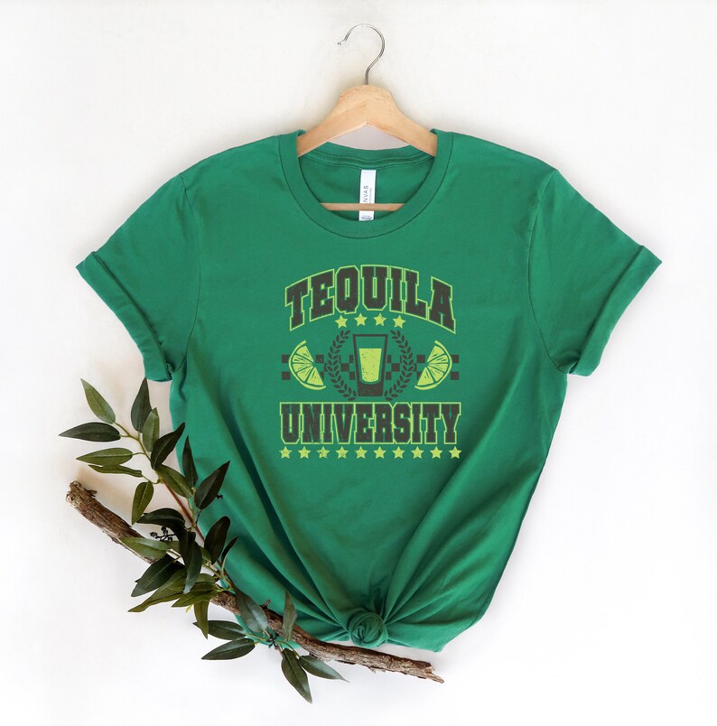 May include: Green t-shirt with the text "Tequila University" in black and yellow lettering. The design includes a shot glass with a lime wedge and stars.