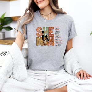 May include: Grey t-shirt with a floral design and the text "SHE is MOM" with bible verses.