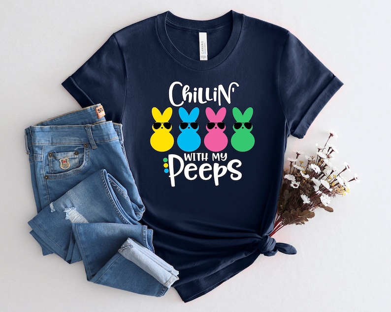 May include: Navy blue t-shirt with a graphic of three yellow, blue, and pink marshmallow peeps wearing sunglasses. The text "Chillin' with my Peeps" is printed below the peeps.