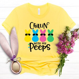 May include: Yellow t-shirt with the text "Chillin' with my peeps" and four colorful marshmallow peeps with sunglasses.