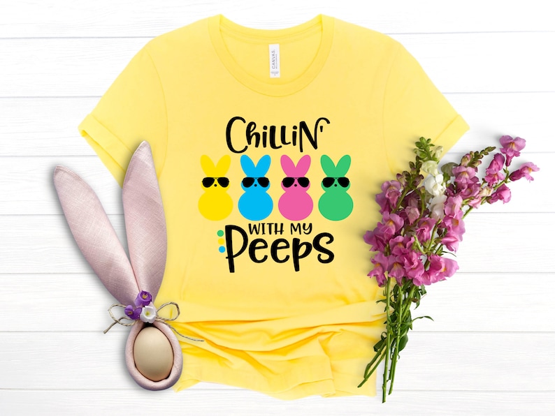 May include: Yellow t-shirt with the text "Chillin' with my peeps" and four colorful marshmallow peeps with sunglasses.