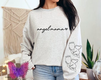 May include: A gray sweatshirt with the text "angel mama" and a heart symbol on the front. The sleeves have a line drawing of an angel on each side.