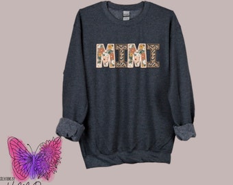 May include: A dark gray sweatshirt with the word "MIMI" printed on the front in floral and animal print letters.