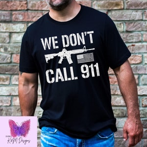 May include: Black t-shirt with a white graphic of a rifle with an American flag and the text "WE DON'T CALL 911".