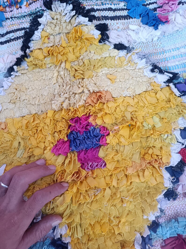 Eco-friendly Moroccan carpet with diamond motifs in green, yellow, orange, and blue.