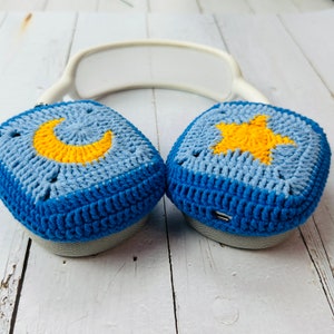 May include: Blue and light blue crocheted headphone covers with a yellow crescent moon on one and a yellow star on the other.