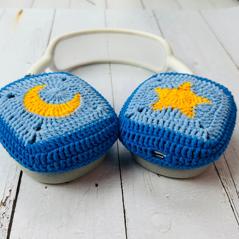 May include: Blue and light blue crocheted headphone covers with a yellow crescent moon on one and a yellow star on the other.