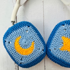 May include: Blue and yellow crocheted headphone covers with a crescent moon design.