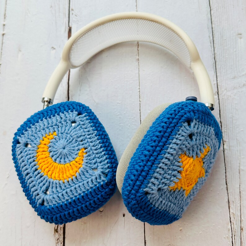 May include: Blue and gray crocheted headphone covers with a yellow crescent moon and star design.