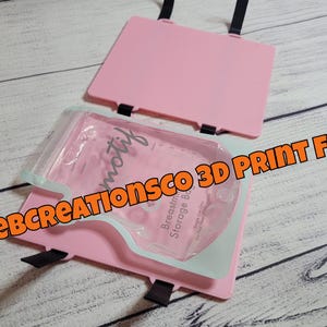 Könnte beinhalten: Ein rosa Aufbewahrungstaschenhalter für Muttermilch mit einer transparenten Plastiktüte im Inneren. Der Halter hat einen Klappdeckel und schwarze Riemen. Der Text "motif" ist auf der Tasche sichtbar. Die Worte "Beebcreationsco 3D Print File" sind orange.