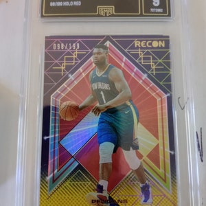 May include: A graded sports card featuring Zion Williamson of the New Orleans Pelicans. The card is a 2021 Recon Holo Red, numbered 98/199 and 098/199. The card is graded a 9 by GMA.