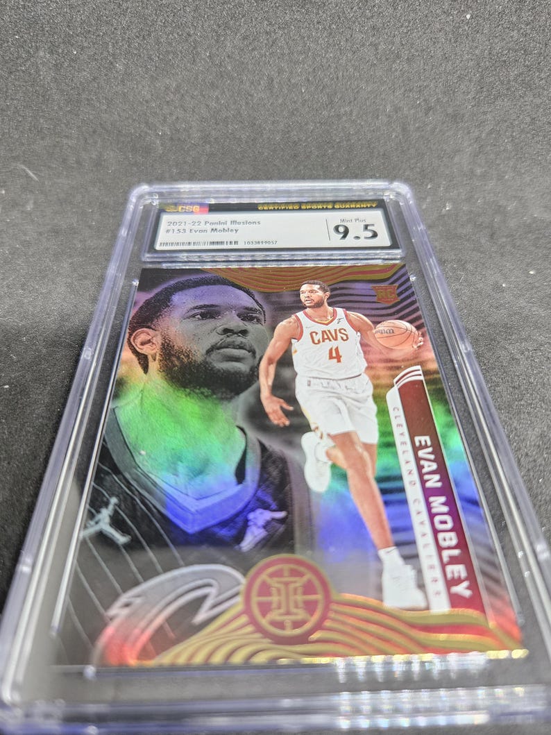 Puede incluir: Una tarjeta coleccionable deportiva calificada con Evan Mobley de los Cleveland Cavaliers. La tarjeta est&aacute; dentro de un soporte protector transparente y calificada con 9.5. La tarjeta tiene un dise&ntilde;o colorido con el jugador en acci&oacute;n.