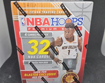 Könnte beinhalten: Eine rot-weiß-schwarze Box für ein NBA Hoops Trading Card Set 2019-20. Die Box zeigt einen Basketballspieler in einem weißen Trikot mit der Aufschrift "New Orleans" auf der Vorderseite. Die Box trägt die Aufschrift "NBA Hoops Premium Stock" und "32 NBA Cards!"