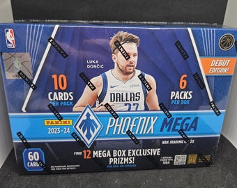 Puede incluir: Una caja azul, blanca y negra para un set de tarjetas de colección de baloncesto Panini Phoenix Mega 2023-24. La caja presenta una foto de Luka Dončić, jugador de los Dallas Mavericks, vistiendo una camiseta azul con el número 77. La caja incluye 10 tarjetas por paquete y 6 paquetes por caja. La caja también incluye 12 prizmas exclusivos de la caja mega por caja, en promedio.