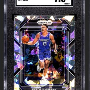 May include: A graded basketball trading card featuring Keegan Murray of the Sacramento Kings. The card is a 2022-23 Panini Prizm Ice Prizm and is graded 9.5 by SGC. The card features a holographic design with a purple and blue color scheme.