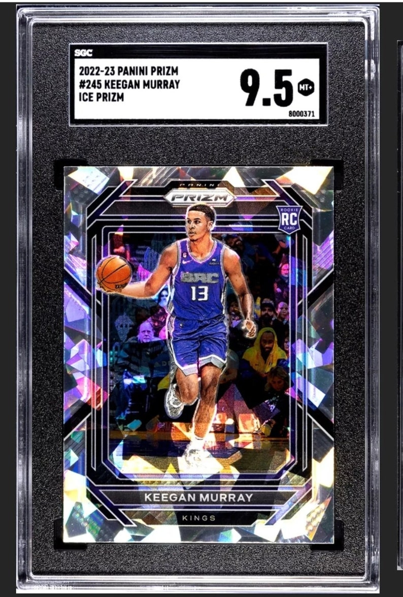May include: A graded basketball trading card featuring Keegan Murray of the Sacramento Kings. The card is a 2022-23 Panini Prizm Ice Prizm and is graded 9.5 by SGC. The card features a holographic design with a purple and blue color scheme.