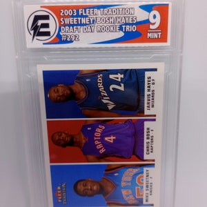 May include: A 2003 Fleer Tradition Draft Day Rookie Trio trading card featuring Mike Sweetney, Chris Bosh, and Jarvis Hayes. The card is graded 9 Mint.