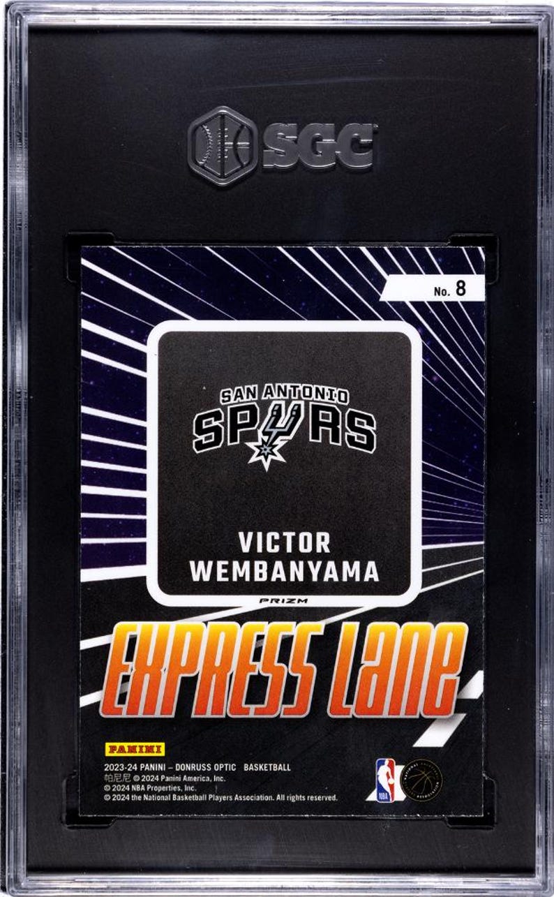 Puede incluir: Una tarjeta de baloncesto 2023-24 Panini Donruss Optic de Victor Wembanyama, con el logotipo de los San Antonio Spurs y el texto Express Lane. La tarjeta est&aacute; encapsulada en una funda protectora negra SGC con el n&uacute;mero 8 en la esquina.