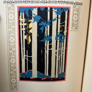 May include: A rectangular book illustration featuring a stylized forest scene with tall, pale tree trunks against a dark background. Blue foliage hangs from the top, with a pink border framing the image and decorative floral scrollwork panels.