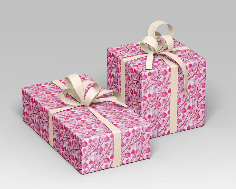 May include: Two gift boxes wrapped in pink patterned paper with a cream-colored ribbon and bow. The paper features a watercolor design of pink berries and branches on a white background. The boxes are rectangular.