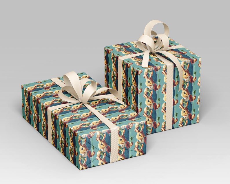 May include: Two gift boxes wrapped in patterned paper featuring a vintage illustration of a rabbit holding a carrot. The boxes are tied with ivory-colored ribbon and bows, set against a light gray background.