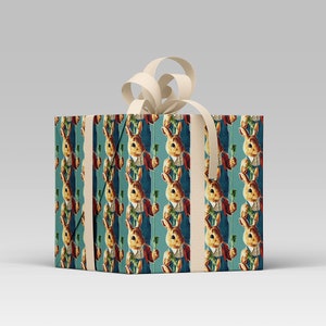 May include: A wrapped gift box featuring a repeating pattern of a rabbit holding a carrot, dressed in a waistcoat and jacket. The background is teal. The box is tied with a cream-colored ribbon and bow.