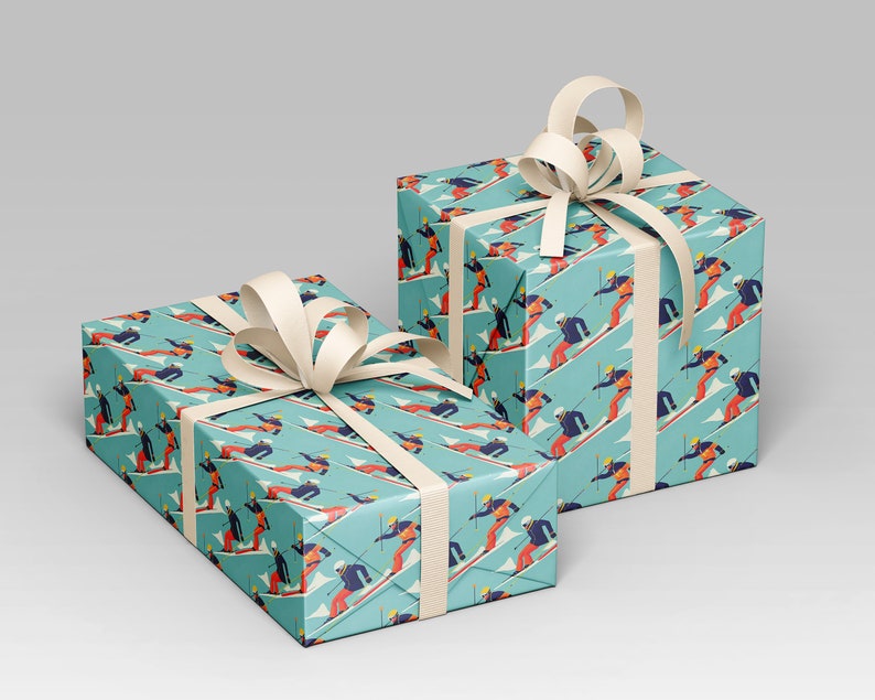 May include: Two gift boxes wrapped in turquoise paper with a repeating pattern of skiers in red, orange, and blue. Each box is tied with a cream-colored ribbon and bow. The boxes are a festive presentation for winter-themed gifts.