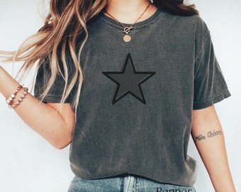 May include: A dark gray t-shirt with a large black star graphic. The shirt is made of a soft, comfortable material and has a relaxed fit.