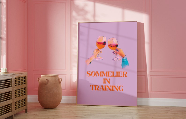 May include: A purple poster with two glasses of red wine clinking together. The text "SOMMELIER IN TRAINING" is printed in orange.