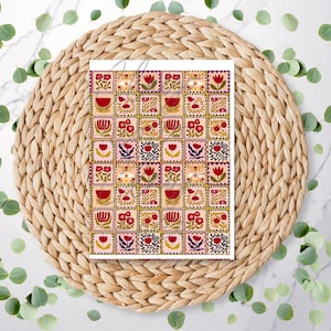 May include: A sheet of floral stamps featuring a repeating pattern of red, pink, and yellow flowers. The stamps are arranged in a grid, with each square showcasing a different floral design. The sheet is placed on a woven placemat.