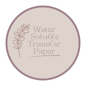Może przedstawiać: Okrągła, jasnofioletowa naklejka z ciemniejszą fioletową obw&oacute;dką. Tekst "Water Soluble Transfer Paper" jest wyświetlany miękką, elegancką czcionką. Po lewej stronie znajduje się delikatna, brązowa ilustracja kwiatowa.
