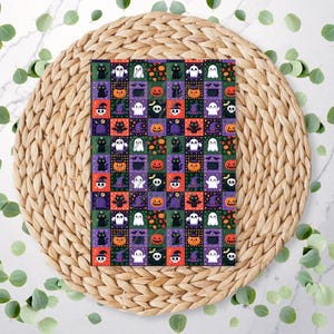 May include: A rectangular card featuring a repeating grid pattern of Halloween icons including white ghosts, orange jack-o'-lanterns, black cats, purple witch hats, skulls, and bats set against alternating dark green, purple, and orange backgrounds.