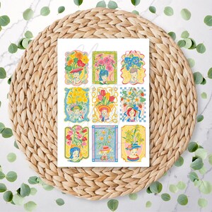 May include: A sheet of nine colourful floral illustrations, each depicting a person with a hat and a vase of flowers. The illustrations are in a vintage style with pastel colours and decorative frames. The sheet is on a woven placemat.