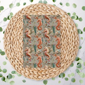 May include: A woven placemat with a beige and brown colour scheme features a repeating pattern of orange and brown seahorses with seashells and seaweed on a green background.